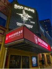Night view of Buckhead Theatre marquee lit up with bright signage promoting an upcoming concert.